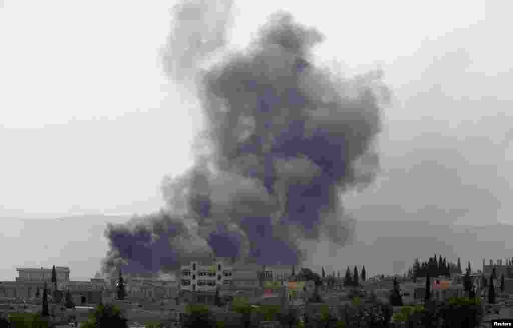 Smoke rises from the Syrian town of Kobani, seen from near the Mursitpinar border crossing on the Turkish-Syrian border in the southeastern town of Suruc, Sanliurfa province, Oct. 3, 2014.