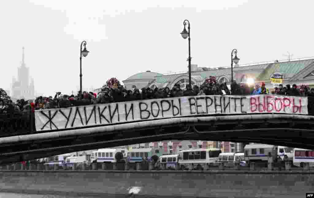 People stand on the bridge as they attend a mass rally to protest against alleged vote rigging in Russia's parliamentary elections in Moscow, Russia, Saturday, Dec. 10, 2011. Many thousands of Russians angered by allegedly fraudulent parliamentary electio