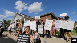 Des manifestants campant jeudi avec affiches et haut-parleurs devant la maison de Walter James Palmer, dans une banlieue de Minneapolis.