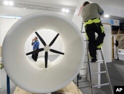 A worker dismantles the exhibition pavilion of Austria as the U.N. climate conference drew to a close in Katowice, Poland, Dec. 15, 2018.