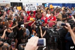 Supporters of Bernie Sanders delegate Nina Turner talk to reporters during protest inside the media tent on July 27, 2016, on the third day of the Democratic National Convention in Philadelphia.