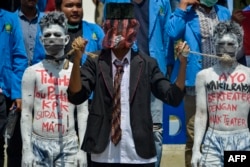 Para demonstran mahasiswa menggelar aksi teater dalam demo menentang rencana pemerintah merevisi Undang-Undang Komisi Pemberantasan Korupsi, di Banda Aceh, 26 September 2019. (Foto: AFP)