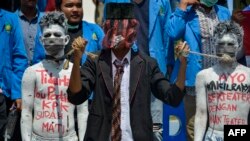 Para demonstran mahasiswa menggelar aksi teater dalam demo menentang rencana pemerintah merevisi Undang-Undang Komisi Pemberantasan Korupsi, di Banda Aceh, 26 September 2019. (Foto: AFp)