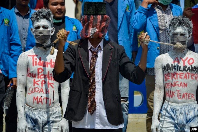 Para demonstran mahasiswa menggelar aksi teater dalam demo menentang rencana pemerintah merevisi Undang-Undang Komisi Pemberantasan Korupsi, di Banda Aceh, 26 September 2019. (Foto: AFP)