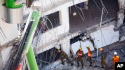 Israeli soldiers from the Home Front Command unit inspect the site of a collapsed multilevel underground parking in Tel Aviv, Sept. 5, 2016. 