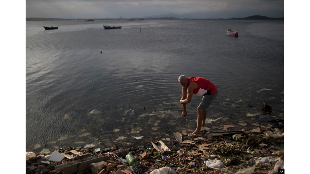 A man washes himself in the polluted waters of Guanabara Bay in Rio de Janeiro, Brazil, July 30, 2016.