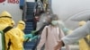 This handout photo taken and released by the Indonesian Embassy on February 2, 2020, shows officials in full protective gear disinfecting Indonesian students as they disembark upon the arrival at Hang Nadim international airport in Batam.