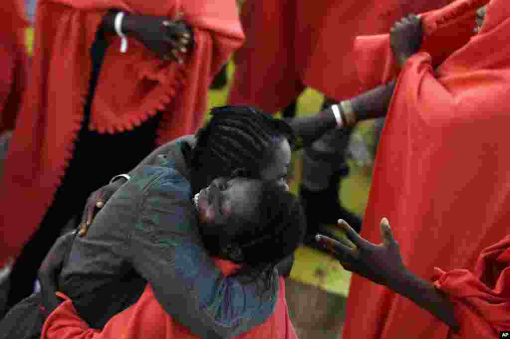 Migrants rescued off the Libyan coast celebrate on the deck of the Siem Pilot Norwegian ship upon their arrival at the Italian port of Cagliari, Sept. 3, 2015.
