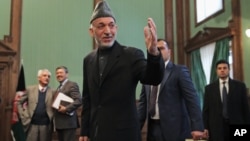 Afghan President Hamid Karzai greets journalists as he leaves a press conference at the presidential palace in Kabul, Afghanistan on Jan. 25, 2014. 