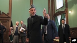 FILE - Afghan President Hamid Karzai leaves a press conference at the presidential palace in Kabul, Afghanistan, Jan. 25, 2014. 