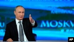 Russian President Vladimir Putin gestures as he answers a question during his annual call-in show in Moscow, April 14, 2016. 