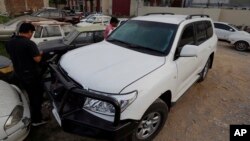 Pakistani journalists examine a car of American diplomate parked inside a police station after an accident in Islamabad, April 7, 2018.