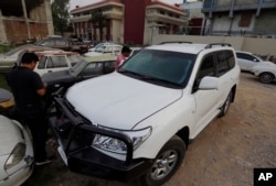 FILE - Pakistani journalists examine the car of an American diplomat parked inside a police station after an accident in Islamabad, Pakistan, April 7, 2018.