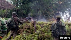 A Congolese soldier shoots in the direction of M23 rebels from their position near the Rumangabo military base in Runyoni, 58 km (36 miles) north of Goma, Oct.31, 2013.