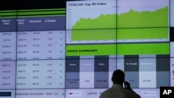 FILE: A worker at the Stock Exchange in Johannesburg, South Africa, uses his mobile phone, April 4, 2017. 