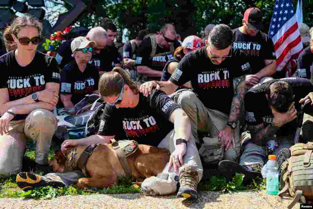 Air Force Veteran Sabrina Weber of Alabama, hugs her service dog during a moment of silence in remembrance of Memorial Day at the Arlington National Cemetery, in Arlington, Virginia, May 27, 2019.