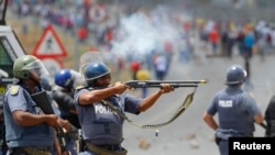 FILE - Police fire on demonstrators during a strike by farm workers at De Doorns on the N1 highway, linking Cape Town and Johannesburg, Jan. 9, 2013.