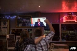 A customer reacts while watching a telecast in a bar in Randburg, Johannesburg, on Feb. 14, 2018, as South African president Jacob Zuma makes a live address to the nation.