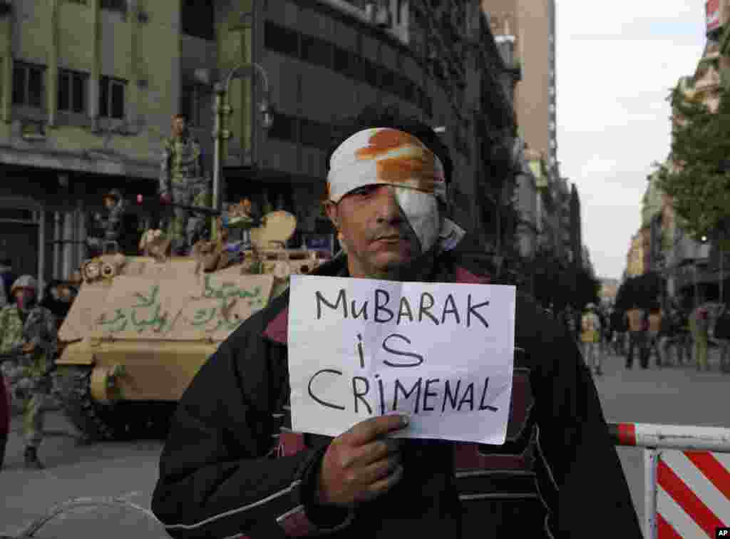 Jedan od povređenih demonstranata pozira uoči izricanja presude biv&scaron;em &scaron;efu države sa parolom&quot;Mubarak je kriminalac&quot;. AP/Manoocher Deghati