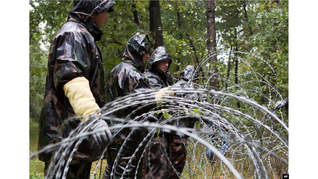 Hungarian soldiers put up spools of razor wire on Slovenian border in Zitkovci, Sept. 25, 2015. Hungary has installed spools of razor wire near a border crossing with Slovenia, which like Hungary is part of the EU's Schengen zone of passport-free travel.