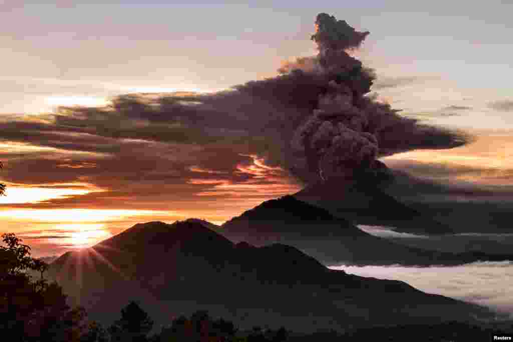 Mount Agung volcano is seen spewing smoke and ash in Bali, Indonesia, in this picture obtained from social media.