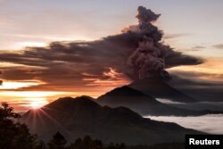 Mount Agung volcano is seen spewing smoke and ash in Bali, Indonesia, November 26, 2017 in this picture obtained from social media.