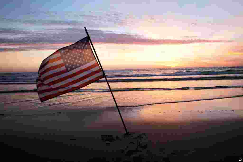 An American flag is placed in the sand of Omaha Beach, western France, as world leaders, veterans and Normandy residents pay tribute to the thousands who gave their lives in the D-Day invasion of Nazi-occupied France 70 years ago, June 6, 2014. 