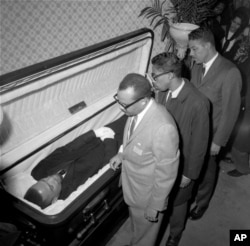 The body of Malcolm X, black nationalist leader who was slain February 21, 1965, at a rally of his organization, is viewed by newsmen at the Unity Funeral Home, Eighth Avenue and 126th Street in New York City February 24, 1965.