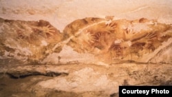 Hand stencils, like the one pictured above from a cave in Sulawesi, are common in prehistoric art. (Credit: Kinez Riza)