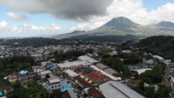 Kompleks Pasar Beriman Tomohon yang berada di tengah kota Tomohon dengan latar gunung Lokon di kejauhan, 10 Maret 2019. (Foto: VOA/Yoanes Litha)