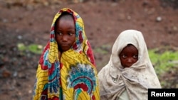 Girls, displaced by recent fighting between Congolese army and the M23 rebels, cover themselves from the cold in Munigi village near Goma in the eastern Democratic Republic of Congo, Sept. 1, 2013.