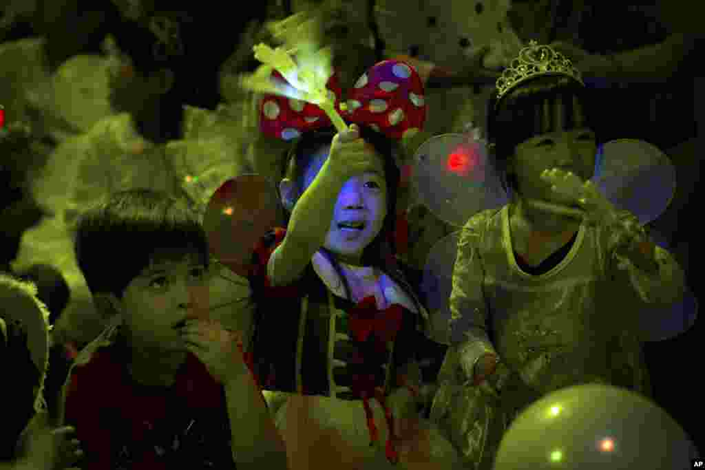 Children cheer while watching a magic show at a Mother&#39;s Day-themed disco dance party for children in Beijing, China.