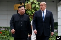 U.S. President Donald Trump and North Korean leader Kim Jong Un take a walk after their first meeting at the Sofitel Legend Metropole Hanoi hotel, Feb. 28, 2019, in Hanoi.