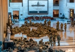 Hundreds of National Guard troops hold inside the Capitol Visitor's Center to reinforce security at the Capitol in Washington, Wednesday, Jan. 13, 2021.