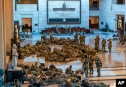 Hundreds of National Guard troops hold inside the Capitol Visitor's Center to reinforce security at the Capitol in Washington, Wednesday, Jan. 13, 2021.