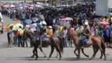 Police on horseback ride past people waiting to view the body of former South African president Nelson Mandela in Pretoria South Africa, Dec. 11, 2013. 