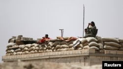 FILE - Fighters of the Syria Democratic Forces (SDF) are seen atop a fortified watch post near Raqqa, Syria, May 27, 2016. The U.S. has been supporting the SDF with weapons and airstrikes.