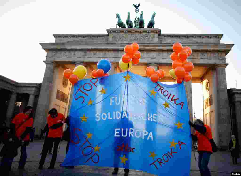 Demonstrators hold a banner reading 'For solidarity in Europe' in front of the Brandenburg Gate in Berlin, November 14, 2012.