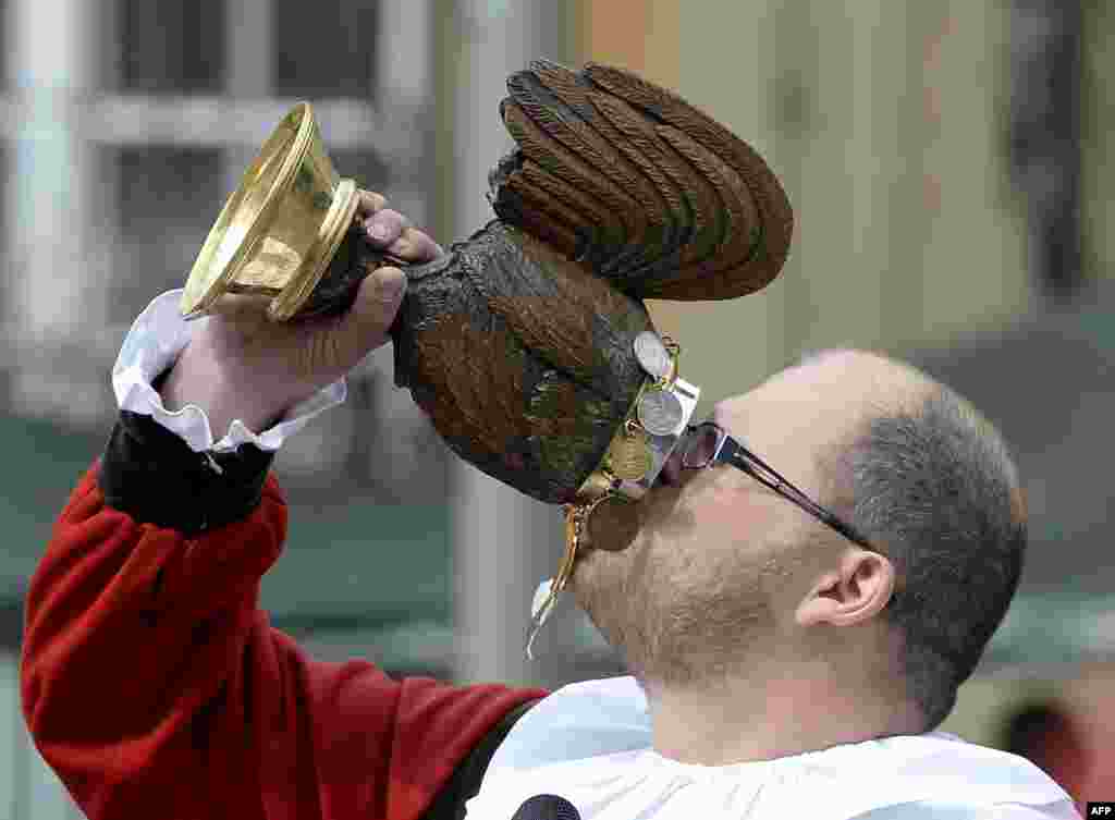 A man drinks from a wooden wine jug during the Salter Festival in Schwaebisch-Hall, southern Germany. The annual salter festival is held since the 14th century to celebrate the salt production that promoted the city of Schwaebisch-Hall. 