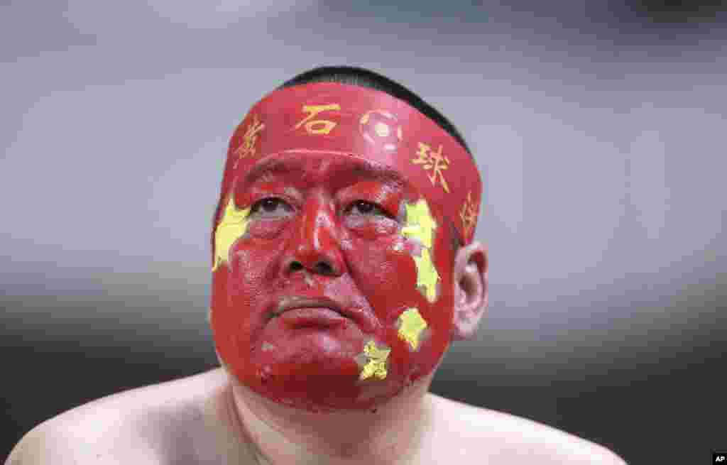 A supporter of the China national soccer team with his face painted in the China&#39;s national color during the soccer match against South Korea for the 2018 FIFA World Cup qualifier at Seoul World Cup Stadium in Seoul, South Korea.