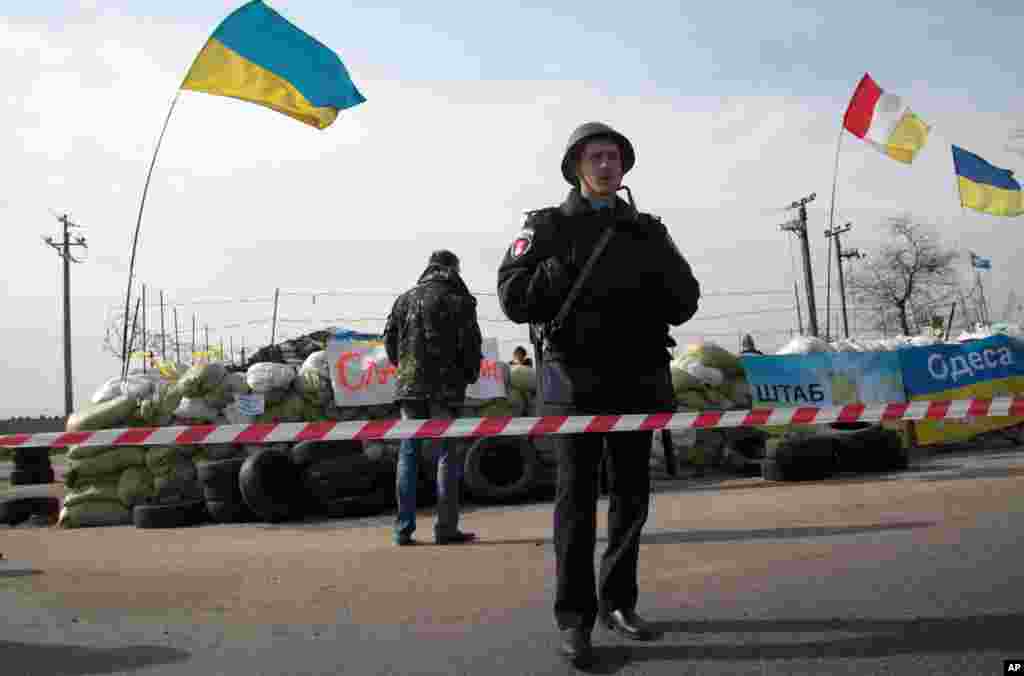 A Ukrainian police officer stands guard at a checkpoint that was attacked by unknown men outside the Black Sea port of Odessa, Ukraine, April 25, 2014. 