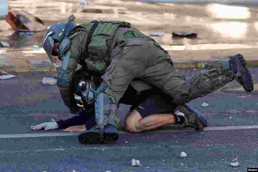 A demonstrator is detained by a member of the security forces during a protest against Chile&#39;s government in Vina del Mar, Feb. 23, 2020.