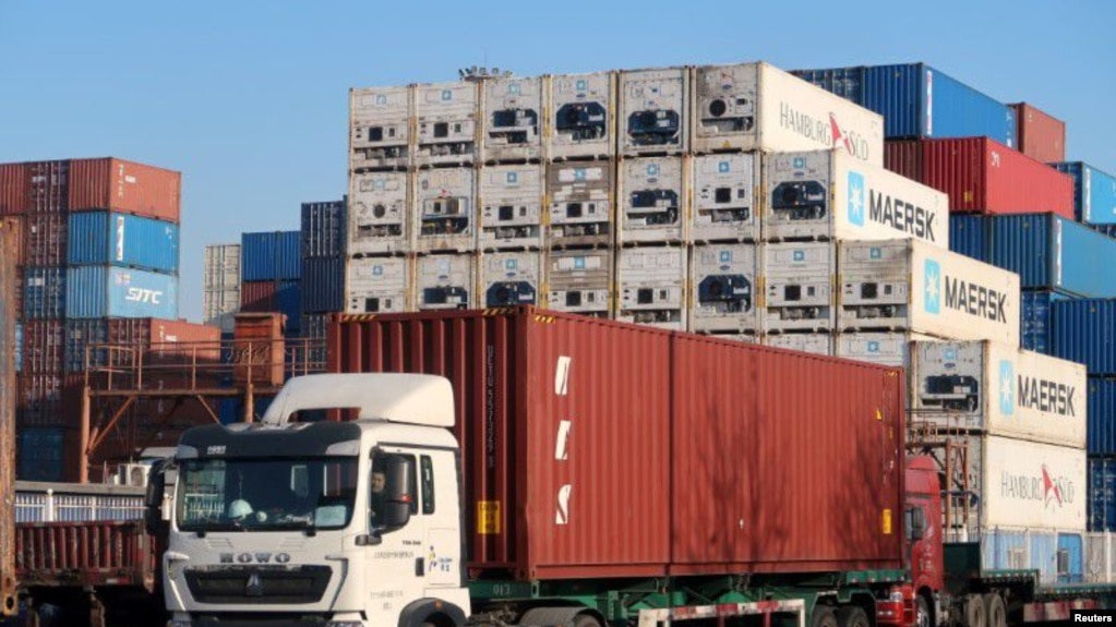 中国天津，一名工人在天津港附近的一个物流中心驾驶一辆载有集装箱的卡车（2019年12月12日）。(photo:VOA)