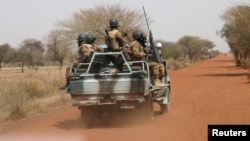 Des soldats patrouillent sur la route de Gorgadji dans la région du Sahel au Burkina Faso, le 3 mars 2019.