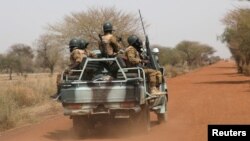 FILE - Soldiers from Burkina Faso patrol on the road of Gorgadji in the Sahel area, Burkina Faso, March 3, 2019.