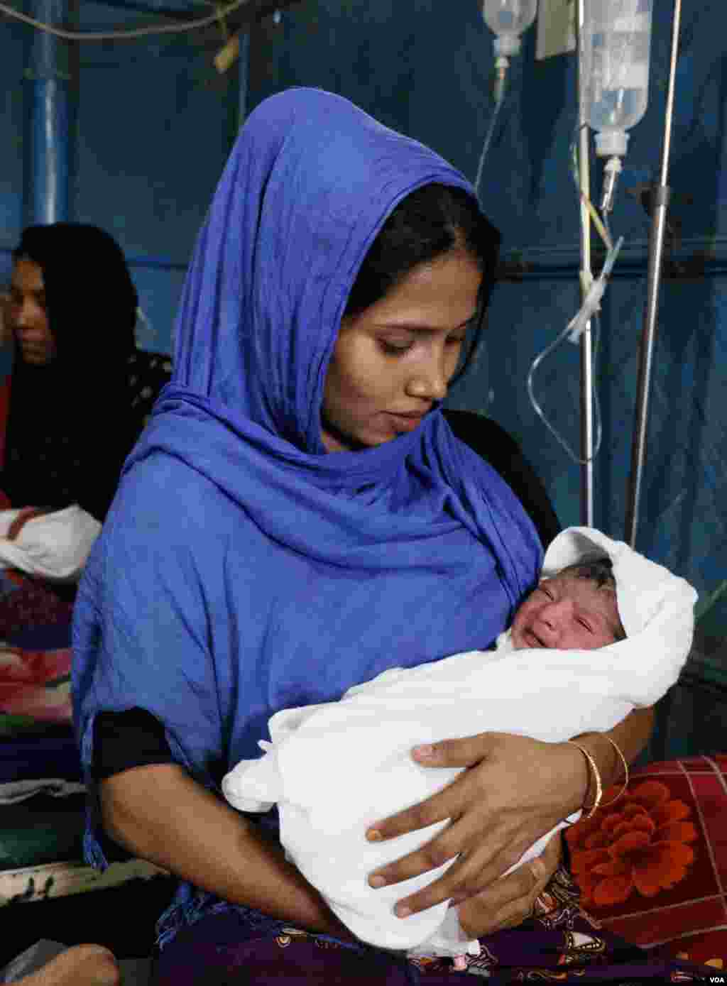 Rohingya refugee Yasmin Ara gets ready to feed her newborn son at the Kutupalong camp Mar. 31, 2019. The baby born four hours earlier that morning is waiting for a name from his grandfather. (Hai Do/VOA)