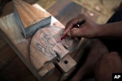 Puspa Lal Shilpakar crafts a wooden piece on a courtyard in Lalitput, Nepal, July 19, 2017.