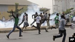 Protesters run away from tear gas fired by police officers during a demonstration against spiraling fuel prices in Lagos, Nigeria, January 16, 2012.