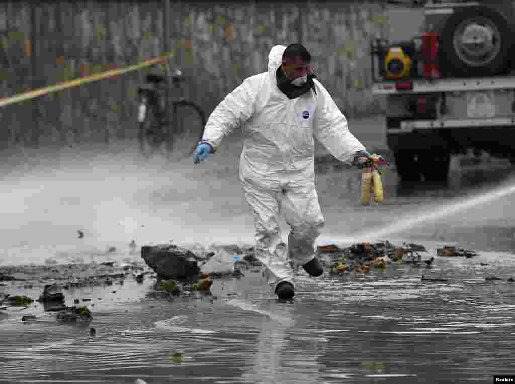 A member of an investigation team holds defused explosives at the site of a suicide attack in Kabul, Afghanistan. A suicide bomber in a car blew himself up close to a police checkpoint near Kabul airport but caused no other casualties, a police spokesman said.