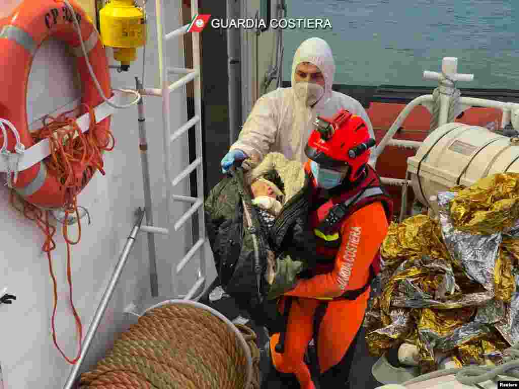 An Italian coastguard member holds a baby in his arms after a rescue operation of a boat in distress carrying migrants in the Mediterranean Sea, near Roccella Jonica, off Calabria coast, Italy.